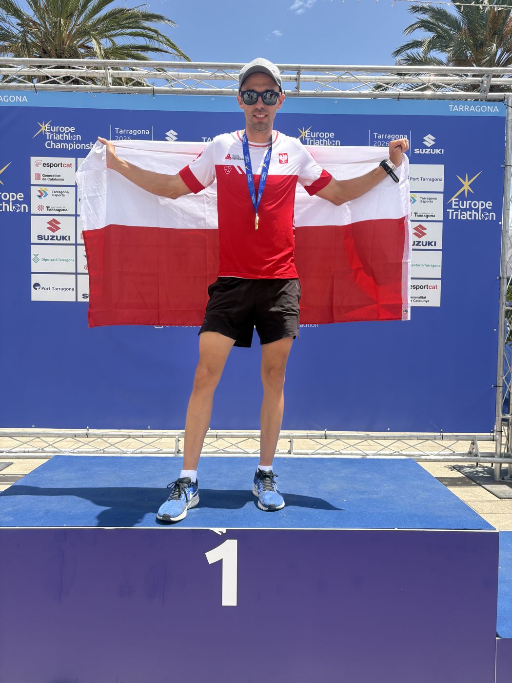 Bartłomiej Stajniak z flagą Polski na najwyższym stopniu podium w Tarragonie